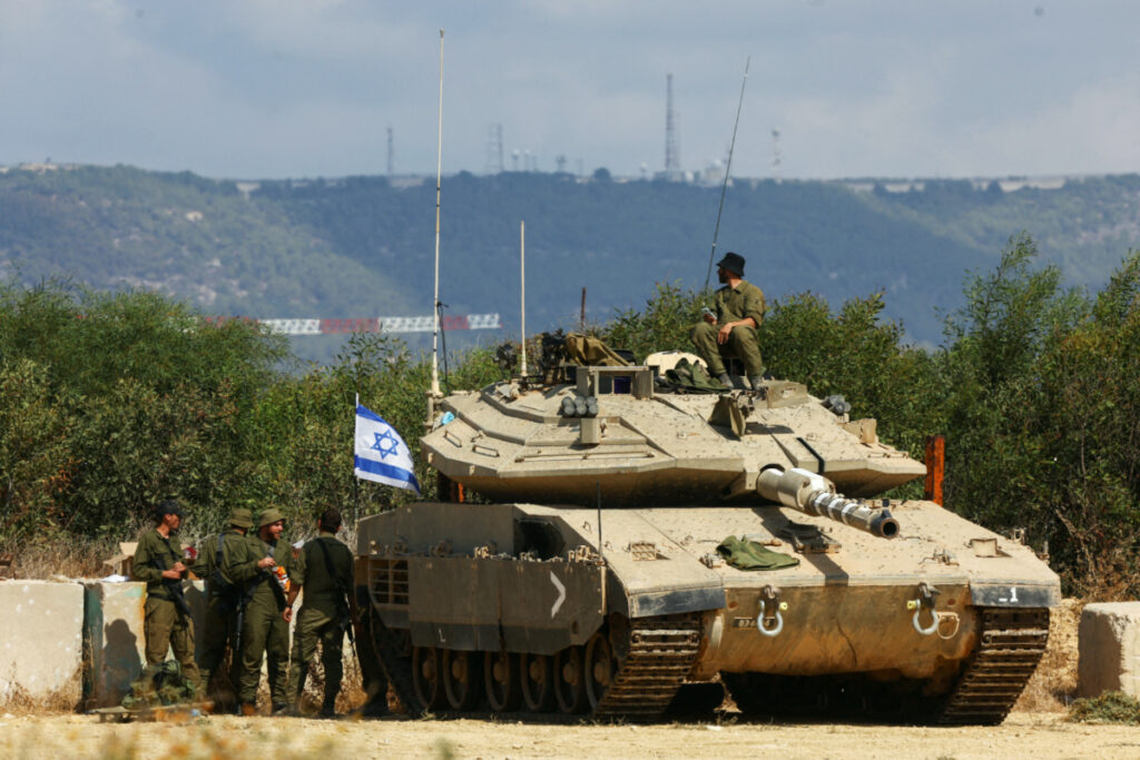 Israeli soldiers stand near to a tank near Israel's border with Lebanon in northern Israel, on 16th October, 2023.