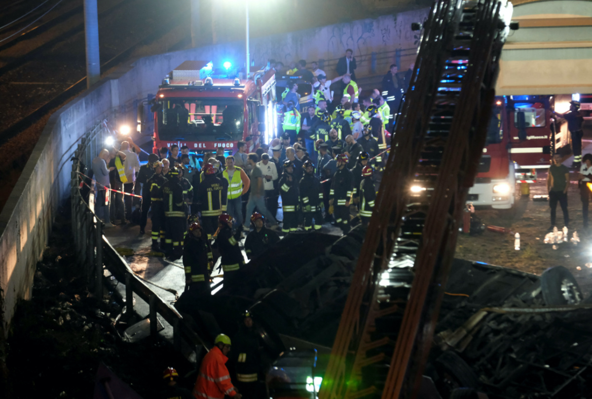 Firefighters and rescue personnel work near a coach after it crashed off an overpass in Mestre, Italy, on 3rd October, 2023
