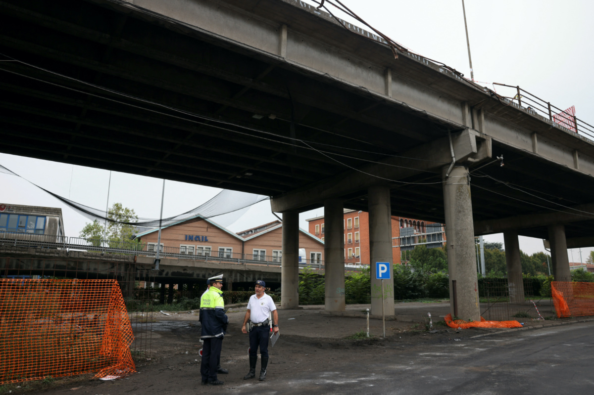 Local police members work at the site where a coach crashed off an overpass in Mestre, Italy, on 4th October, 2023