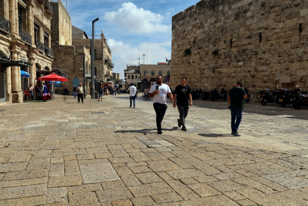 People walk into Jerusalem's Old City via Jaffa Gate, as the conflict wreaks havoc across the tourism sector, on 11th October, 2023