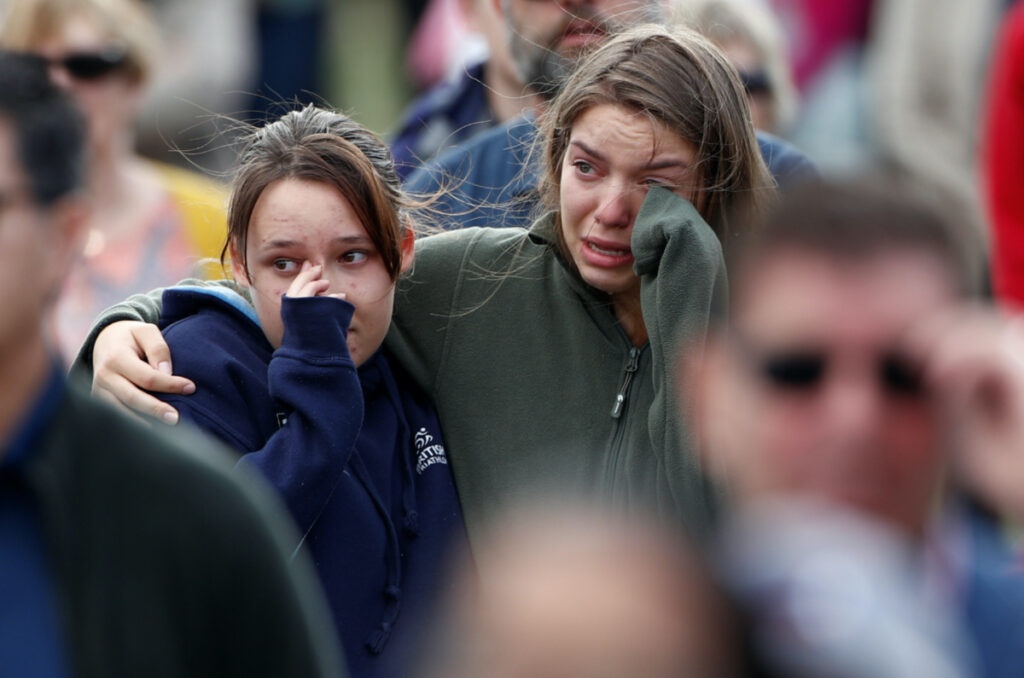 Women react as the national anthem is played during the national remembrance service for victims of the mosque attacks, at Hagley Park in Christchurch, New Zealand on 29th March, 2019