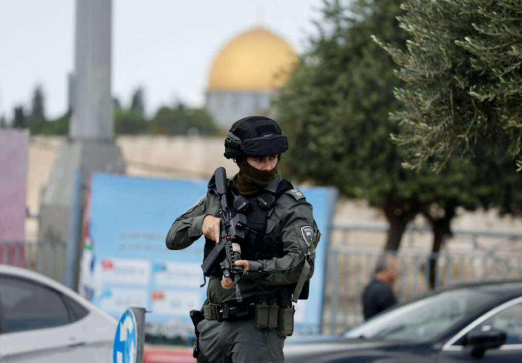 A member of Israeli border police stands guard as Palestinians attend Friday prayers outside the Old City of Jerusalem, on 20th October, 2023