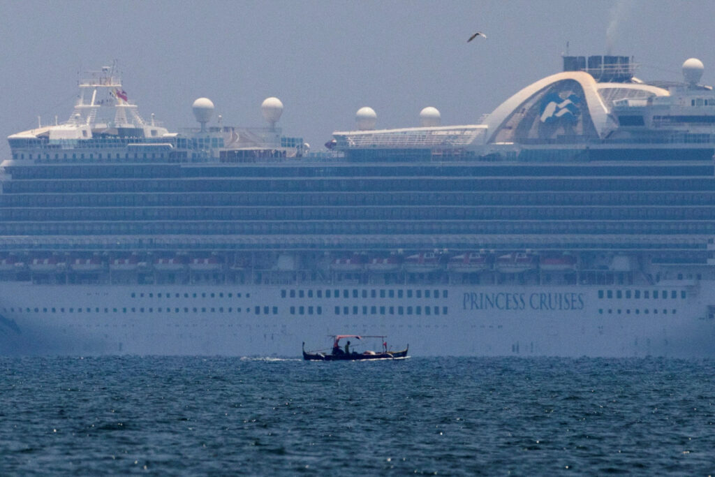 A fishing boat sails past the Princess Cruises' Ruby Princess cruise ship as it docks in Manila Bay during the spread of the coronavirus disease, in Cavite city, Philippines, on 7th May, 2020