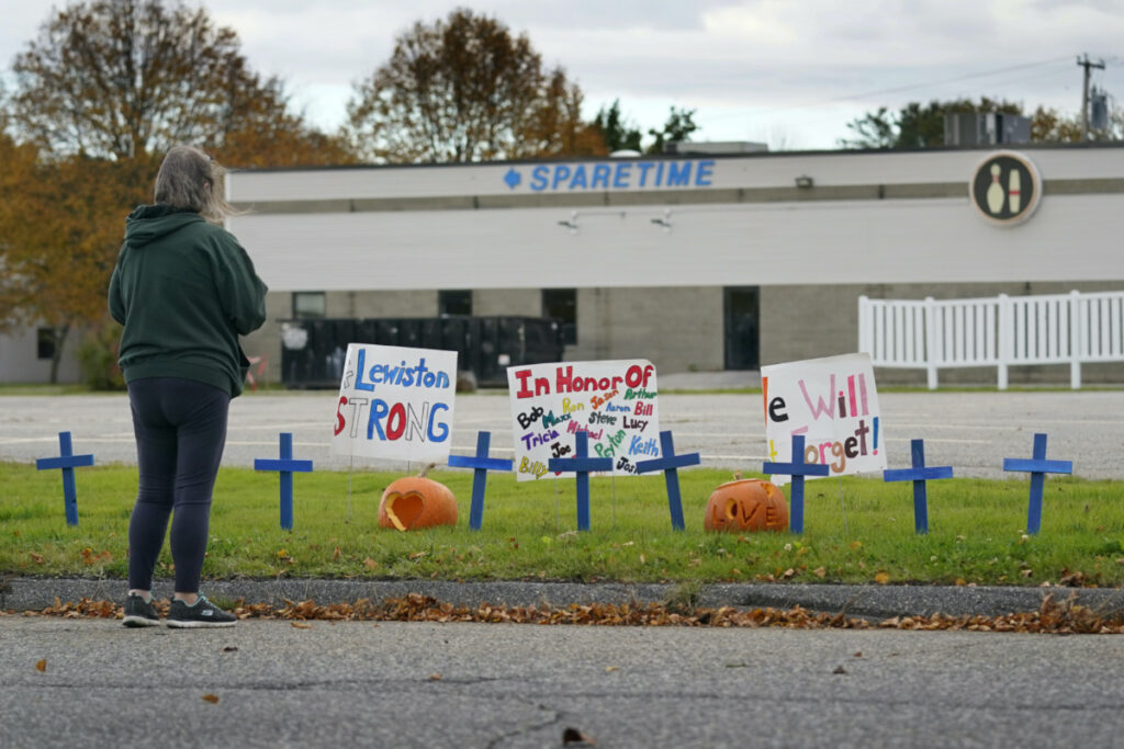 A woman visits a makeshift memorial outside Sparetime Bowling Alley, the site of one of this week's mass shootings, on Saturday, 28th October, 2023, in Lewiston, Maine