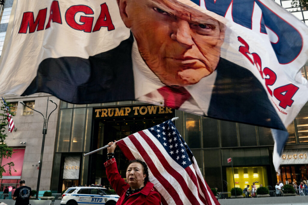 A supporter of former US President Donald Trump holds up a US national flag at Trump Tower in New York City, US, on 1st October, 2023