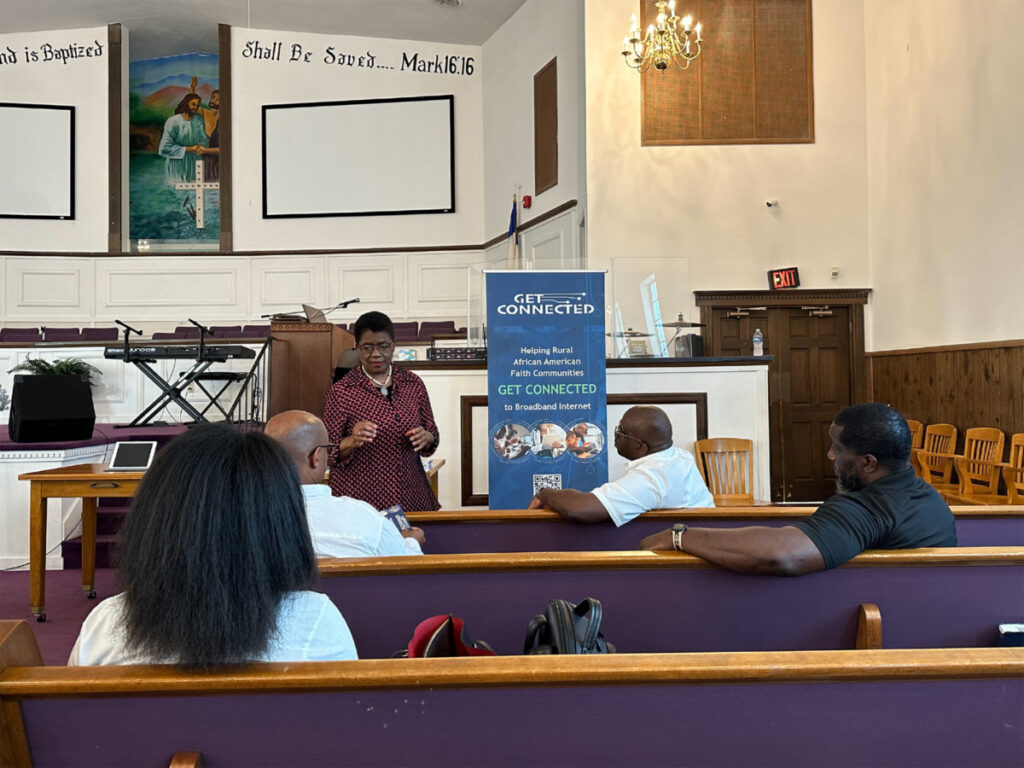 Rev Barbara Williams-Skinner, center, teachers local clergy about the Affordable Connectivity Program during a training event in Jacksonville, Florida.