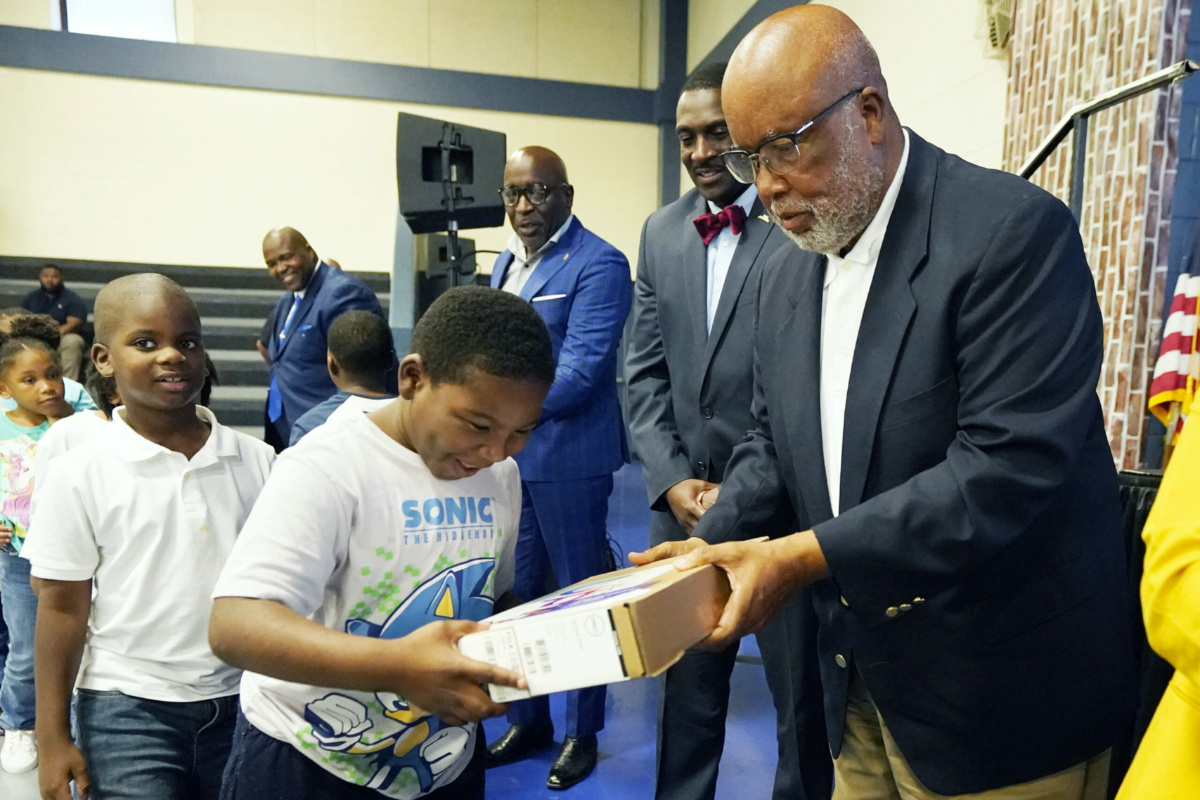 US Rep. Bennie Thompson, right, hands a Bolton-Edwards Elementary/Middle School student a new laptop during a celebration hosted by media and technology company, Comcast, announcing that they completed a broadband expansion effort in the neighbouring towns of Bolton and Edwards, on Tuesday, 22nd August, 2023, in Bolton, Mississippi, US