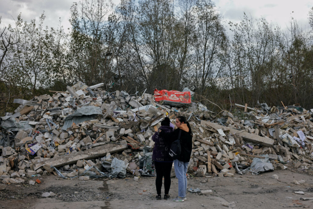 Two women react in front of a pile of rubble that is left of the cafe that hosted the wake and was hit by a Russian missile, following a Russian military strike, amid Russia's attack on Ukraine, in the village of Hroza, Kharkiv region, Ukraine, on 6th October, 2023