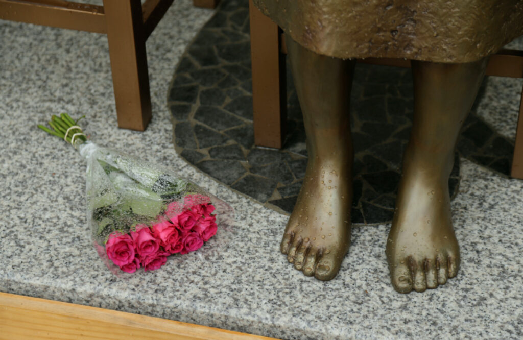 A bouquet lays alongside a statue commemorating Korean "comfort women" at a Sydney church in Sydney, Australia, on 15th December, 2016