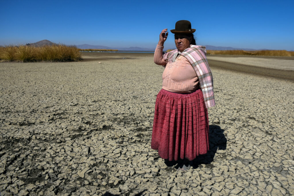 Isabel Apaza shows the area of Lake Titicaca without water in drought season, in Huarina, Bolivia on 3rd August, 2023.