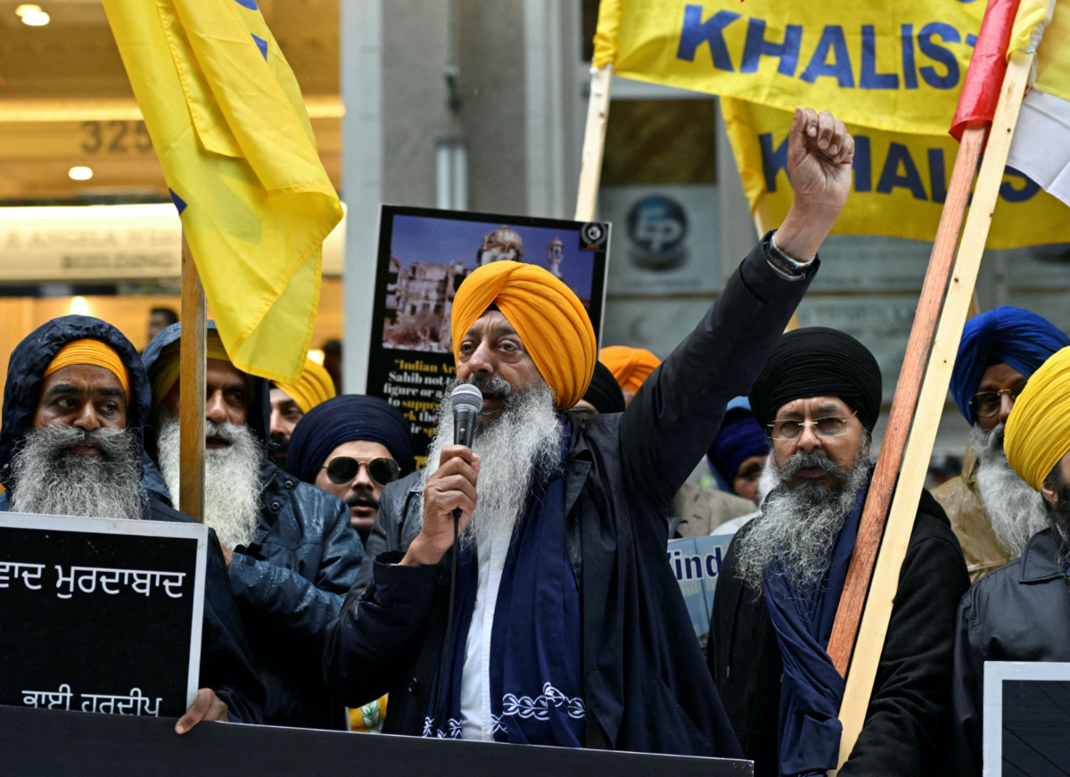 A demonstrator uses a microphone as others hold flags and signs as they protest outside India's consulate, a week after Canada's Prime Minister Justin Trudeau raised the prospect of New Delhi's involvement in the murder of Sikh separatist leader Hardeep Singh Nijjar, in Vancouver, British Columbia, Canada, on 25th September, 2023.