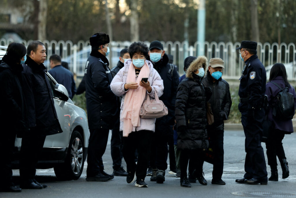 Family members walk past police officers before court hearings on compensation for those who lost their loved ones on the Malaysia Airlines flight MH370 that went missing in 2014, near the People's Court of Chaoyang district in Beijing, China, on 27th November, 2023