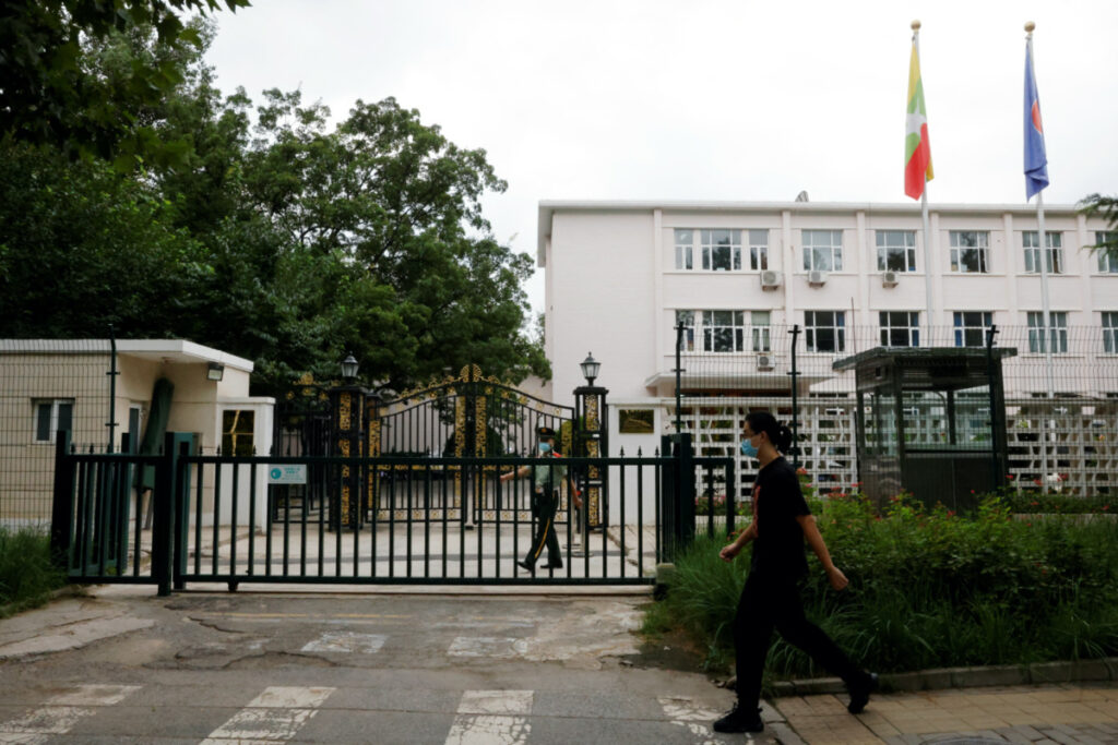 A man walks past a paramilitary police officer keeping watch outside the Myanmar embassy in Beijing, China on 8th August, 2022