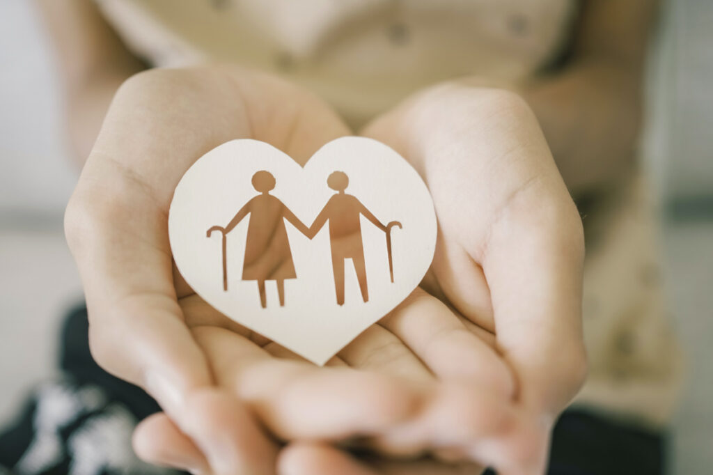 Teen hands holding elderly couple with walking sticks in heart shape, older people mental health, age care concept