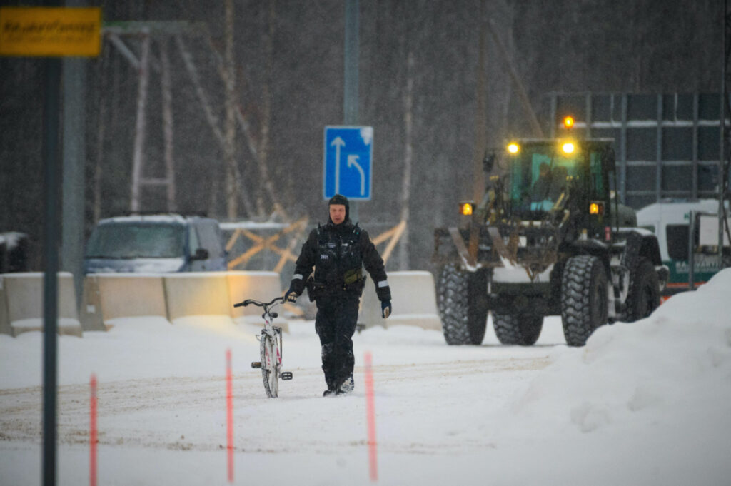 A border guard holds a bicycle of an asylum seeker at the Vartius border station in Kuhmo, Finland, November 19, 2023. Lehtikuva/Miska Puumala via REUTERS