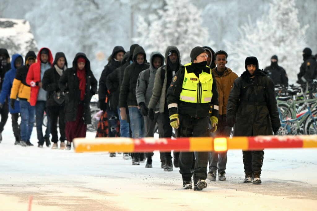Finnish Border Guards escort the migrants at the international border crossing at Salla, northern Finland, on 23rd November, 2023
