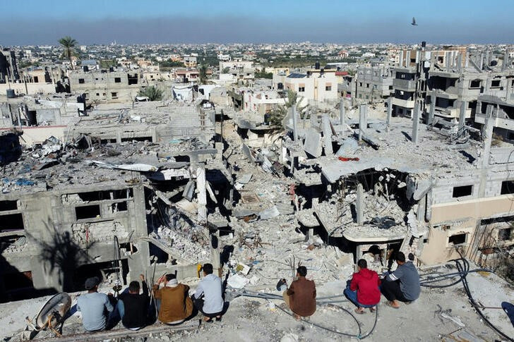 Palestinians look at the houses destroyed in Israeli strikes during the conflict, amid the temporary truce between Israel and the Palestinian Islamist group Hamas, at Khan Younis refugee camp, in the southern Gaza Strip, on 29th November, 2023