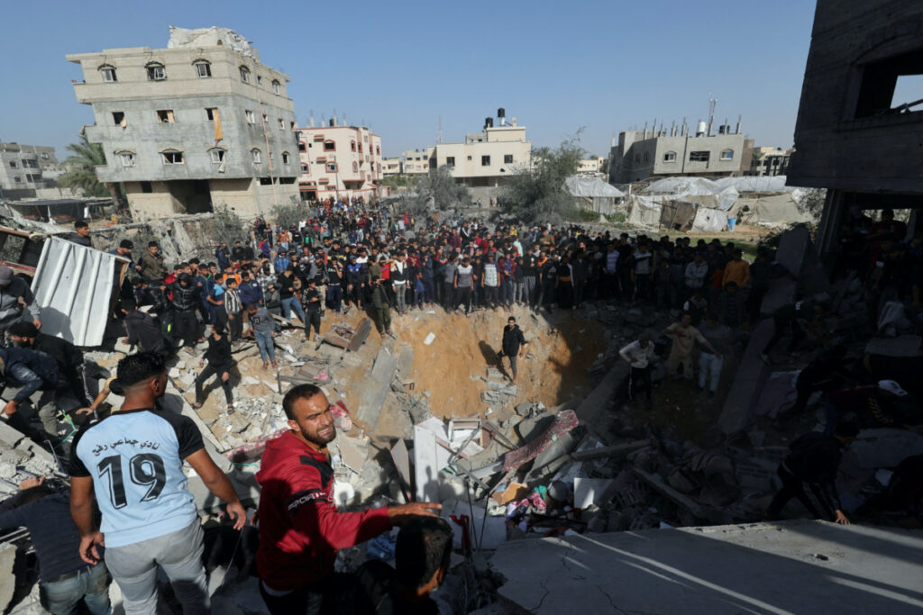 Palestinians gather as others search for casualties at the site of an Israeli strike on a house in Rafah, amid the ongoing conflict between Israel and the Palestinian Islamist group Hamas, in the southern Gaza Strip on 23rd November, 2023