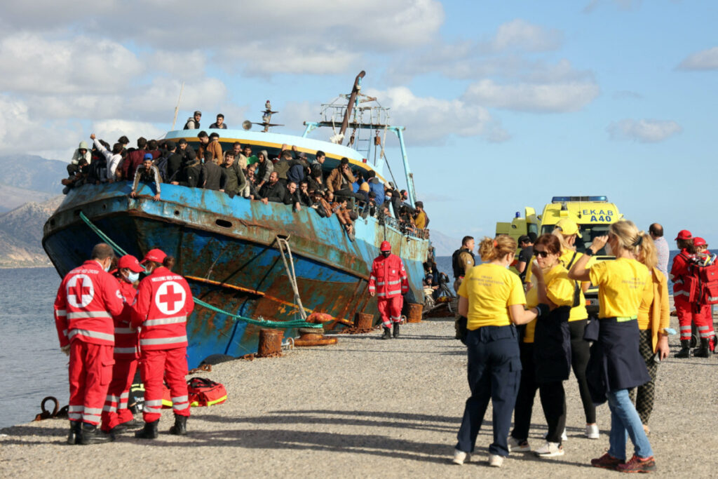 Red Cross volunteers and rescue crews stand next to a fishing boat carrying migrants at the port of Paleochora, following a rescue operation off the island of Crete, Greece, on 22nd November, 2022.