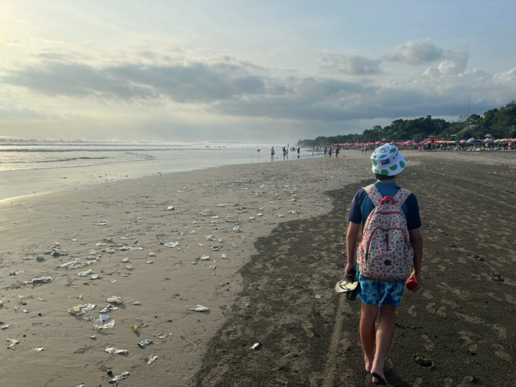 A boy walks on a beach polluted by plastic trash in Bali, Indonesia, on 17th April, 2023.