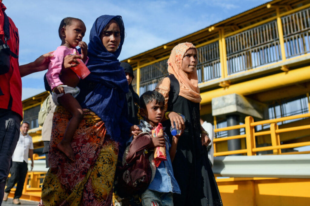 Rohingya Muslims walk as they are being transported to a temporary shelter, following their arrival in Sabang, Aceh province, Indonesia, on 22nd November, 2023