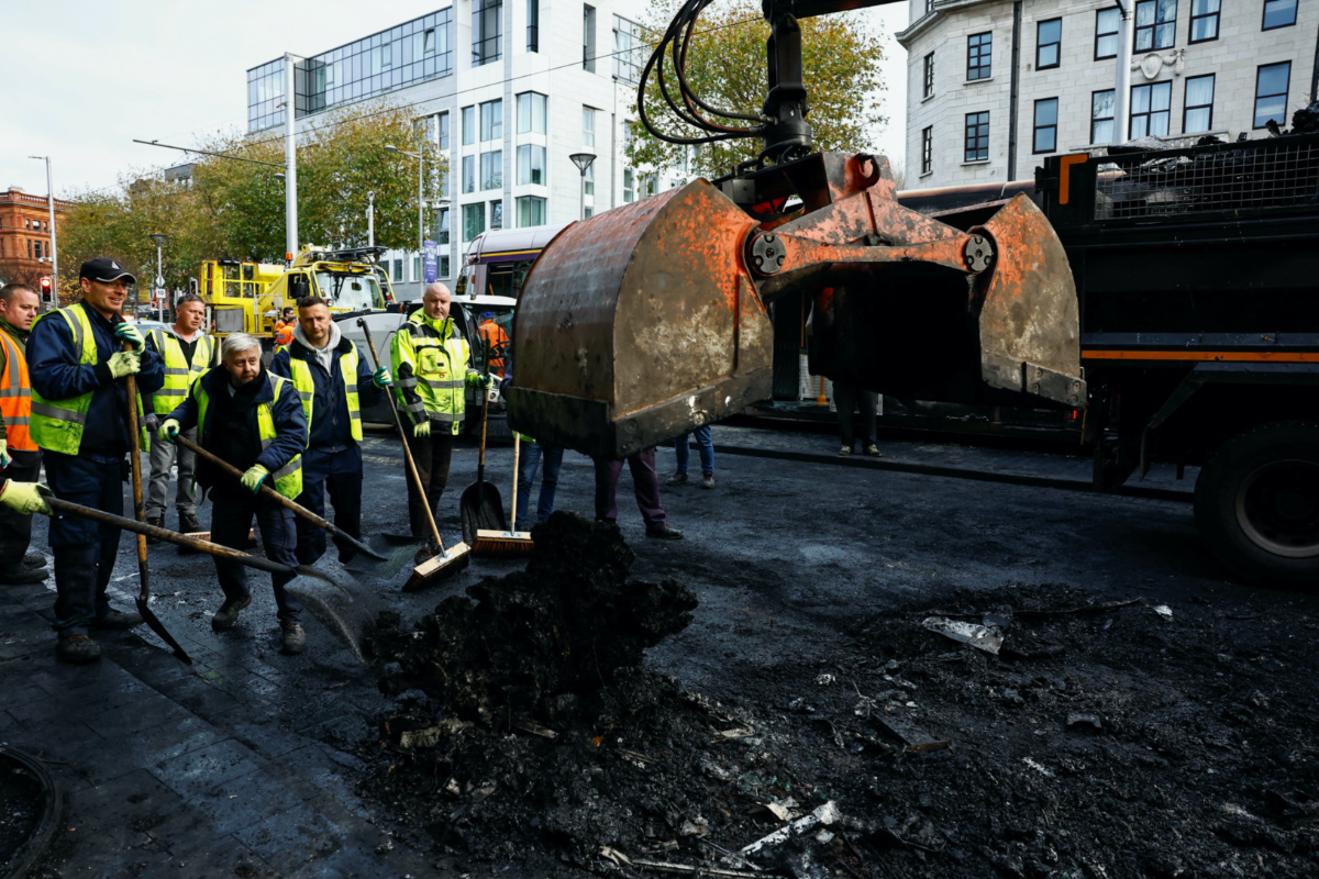 Workers remove remains of burned vehicles, following a riot in the aftermath of a school stabbing that left several children and adults injured, in Dublin, Ireland on 24th November, 2023.