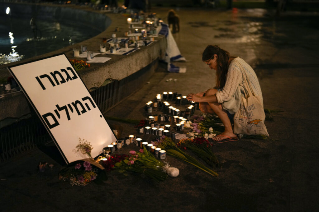 A woman lights candles in honor of victims of the Hamas attacks during a vigil at Dizengoff square in central Tel Aviv, Israel, on Friday, 13th October, 2023.