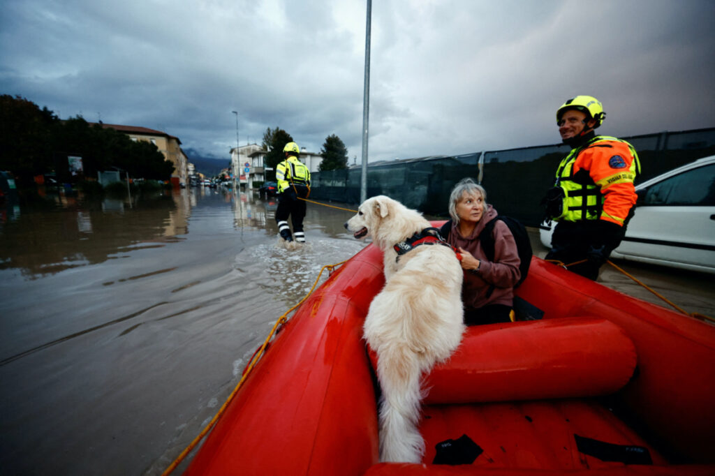 Carla and her dog Dante are carried on a fire brigade dinghy after being rescued in the aftermath of Storm Ciaran, in Oste, in Tuscany region, Italy, on 3rd November, 2023.