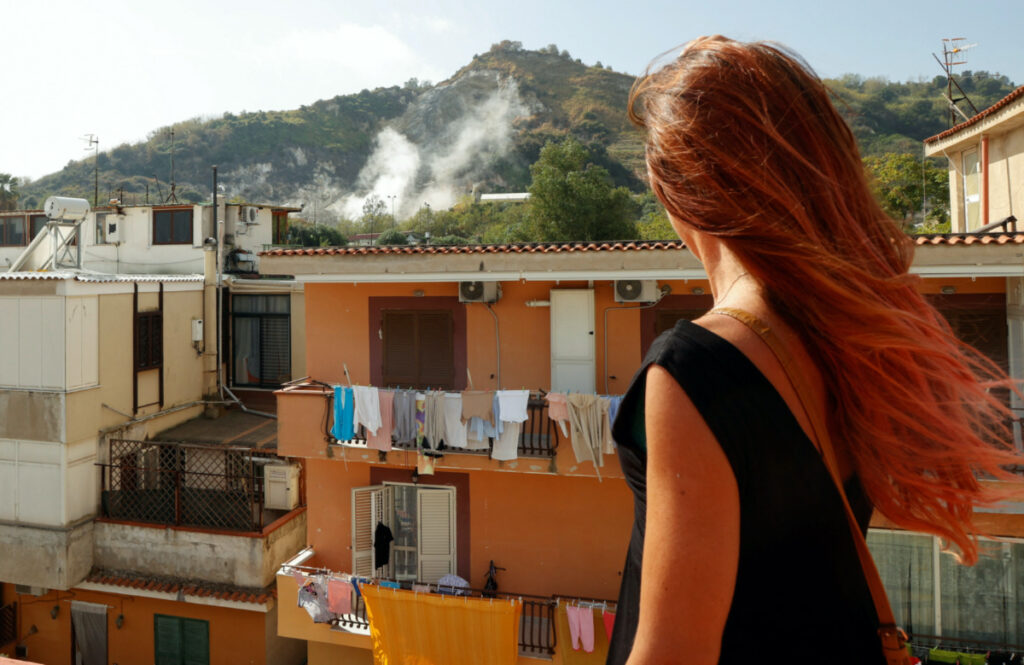 Stefania Briganti, a ballerina in Milan looks at the sulphuric fumes billowing from the Campi Flegrei volcanic region in Pozzuoli, as she plans to move to Pozzuoli to be with her boyfriend despite repeated earthquakes in the area, Italy, on 10th October, 2023.