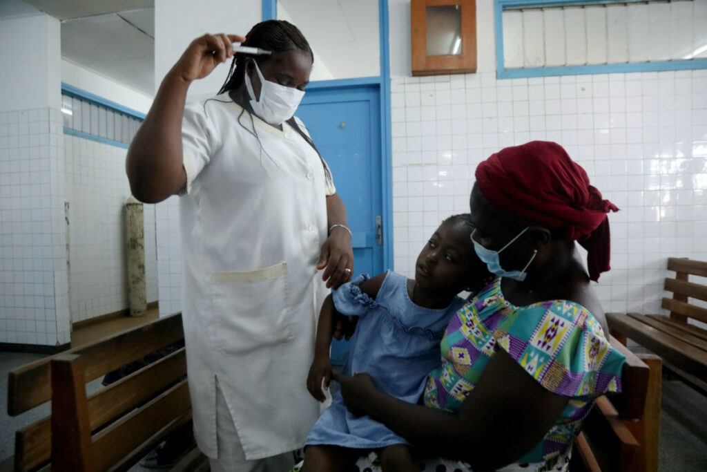 A nurse prepares to take the temperature of a child with malaria at Marcory General Hospital in Abidjan, Ivory Coast on 7th October, 2021