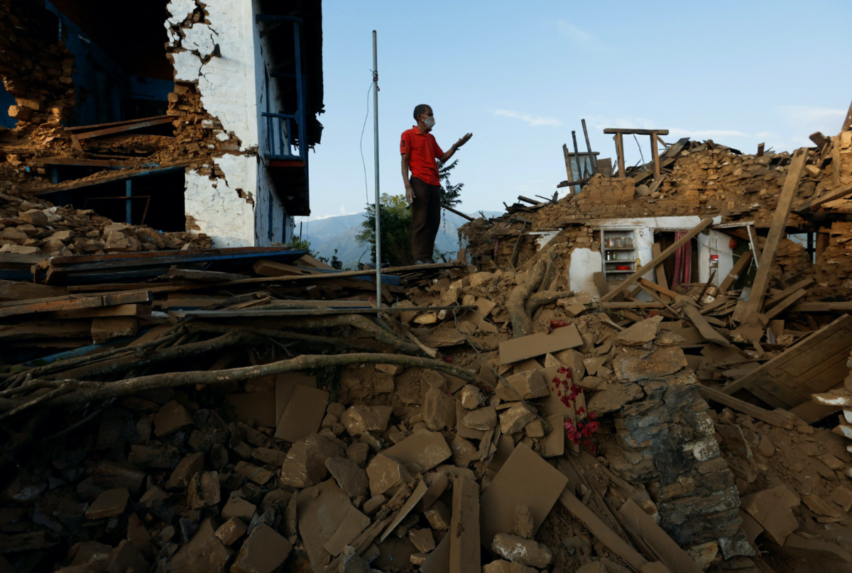 A man stands ontop of the debris of collapsed houses after an earthquake in Jajarkot, Nepal on 5th November, 2023