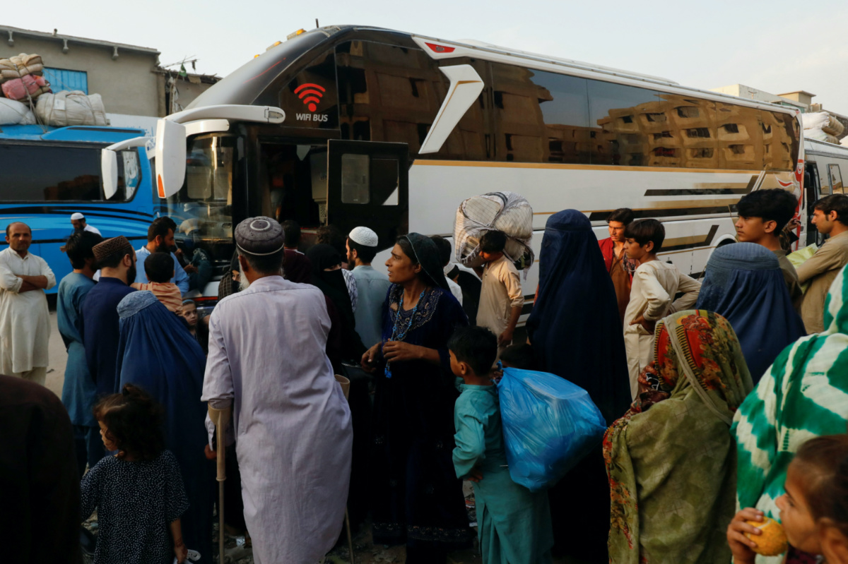 Afghan people gather to board a bus to return home, after Pakistan gave the last warning to undocumented migrants to leave, at a bus stop in Karachi, Pakistan, on 25th October, 2023