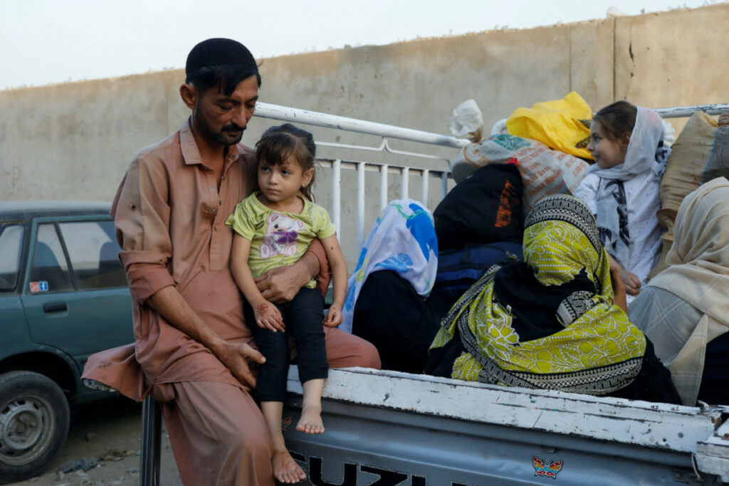 Muhammad Rahim, 35, a driver and father of two, who was born in Karachi in an Afghan family, sits with his family in a pickup van as they prepare to return home, after Pakistan gave last warning to undocumented migrants to leave, at a bus stop in Karachi, Pakistan on 29th October, 2023