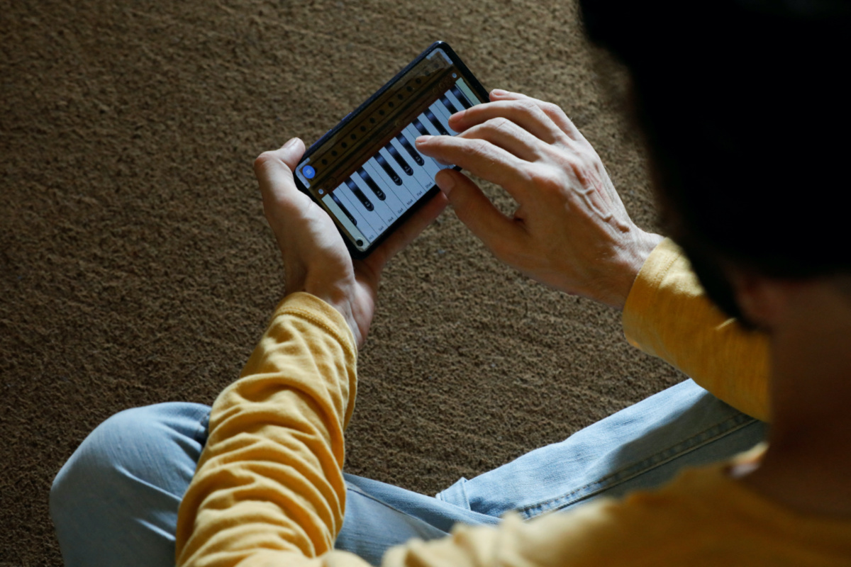 Saleh Zada, 32, a singer and songwriter, who was born in Badakhshan province and later moved to Kabul for his education, plays a music composition on his mobile harmonium app during an interview with Reuters, in Karachi, Pakistan, on 4th November, 2023