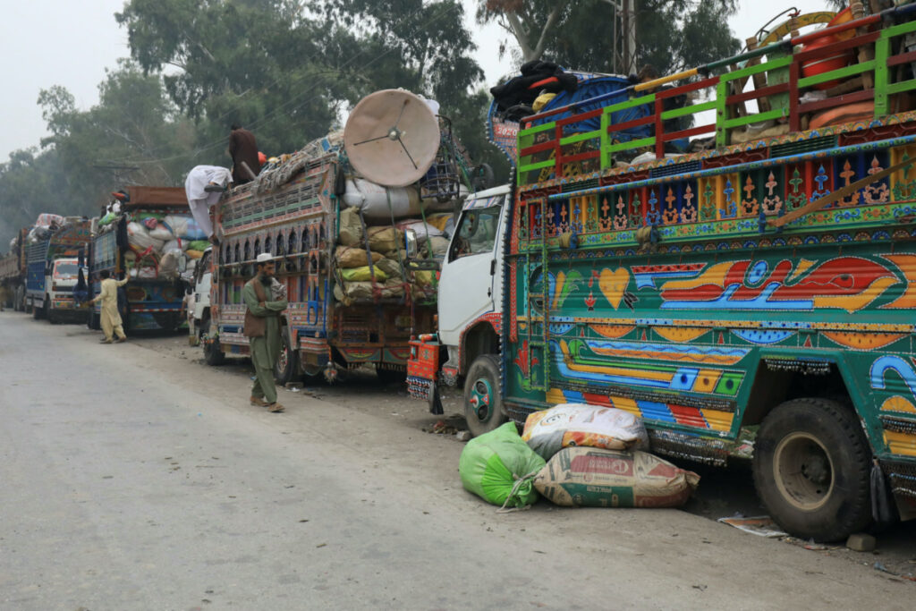 A man walks past trucks loaded with belongings as Afghan nationals are returning home, after Pakistan gives the last warning to undocumented immigrants to leave, outside the United Nations High Commissioner for Refugees, repatriation centres in Azakhel town in Nowshera, Pakistan on 1st November, 2023