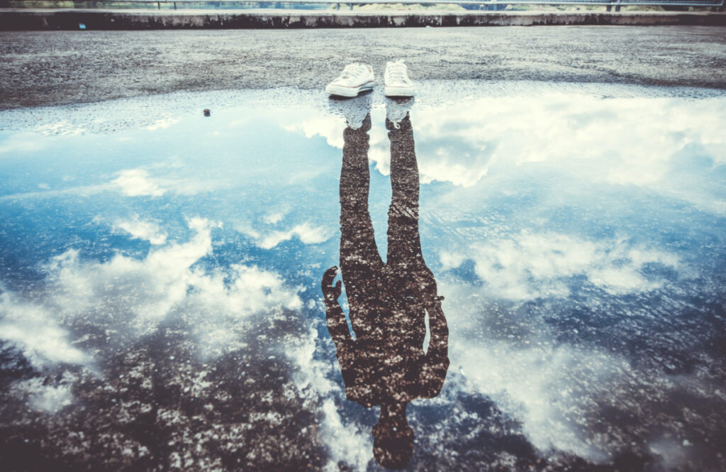 Reflection of man standing near puddle