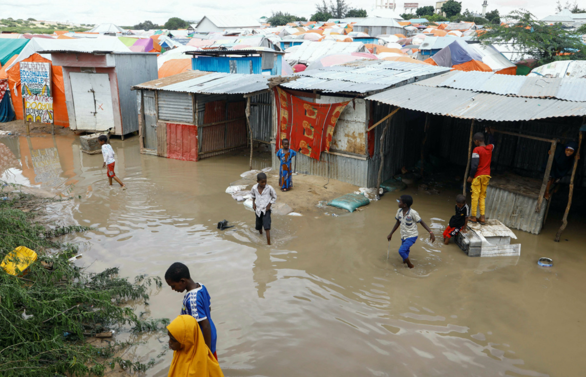 Internally displaced Somali children wade through flood waters outside their makeshift shelters following heavy rains at the Al Hidaya camp for the internally displaced people on the outskirts of Mogadishu, Somalia, on 6th November, 2023