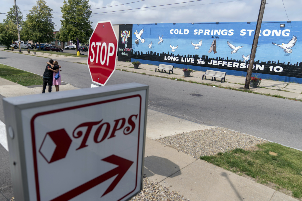 On Monday, 21st August, 2023, two people embrace outside a mural memorialising the 10 people killed when a shooter targeted Black shoppers at a Tops supermarket in 2022, in Buffalo, New York, US