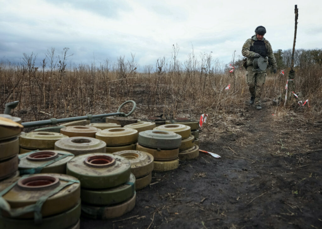 A member of the National Police special demining unit walks past deactivated mines during a demining operation near Izum town, amid Russia's attack on Ukraine, in Kharkiv region, Ukraine, on 24th October, 2023