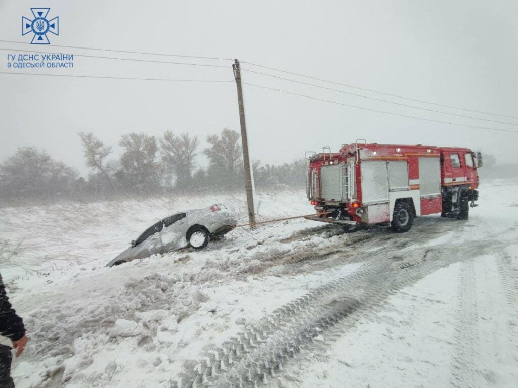 Emergency workers release a car which is stuck in snow during a heavy snow storm in Odesa region, Ukraine in this handout picture released on 27th November, 2023.