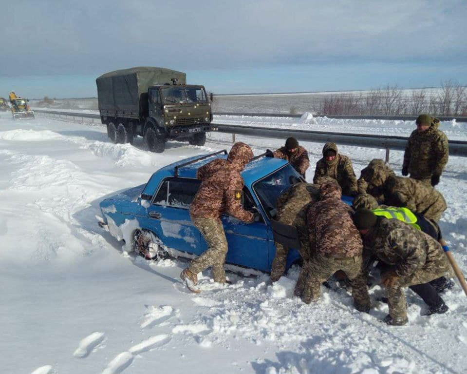 Ukrainian service members release a car which is stuck in snow following a heavy snowstorm in Odesa region, Ukraine, in this handout picture released on 28th November, 2023.