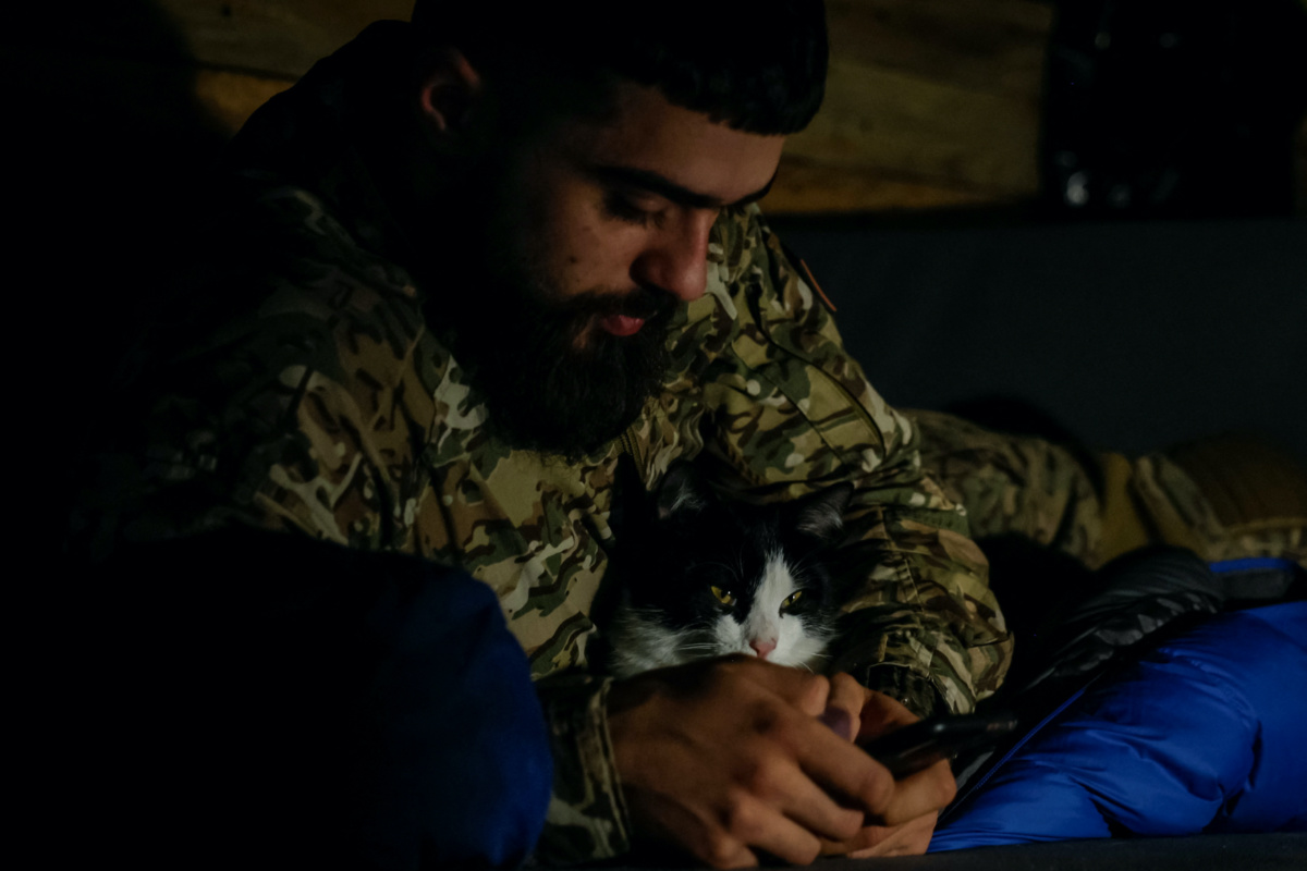 A serviceman of the 67th Mechanised Brigade of the Armed Forces of Ukraine rests with his cat inside a dugout side of a position in a frontline near Kreminna, amid Russia's attack on Ukraine, in Luhansk region, Ukraine, on 2nd November, 2023