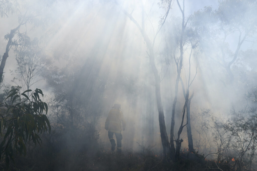 A firefighter walks through a wall of smoke as New South Wales Rural Fire Service personnel conduct a controlled burn to eliminate fuels before the upcoming bushfire season in the Arcadia suburb of Sydney, Australia, on 8th September, 2020