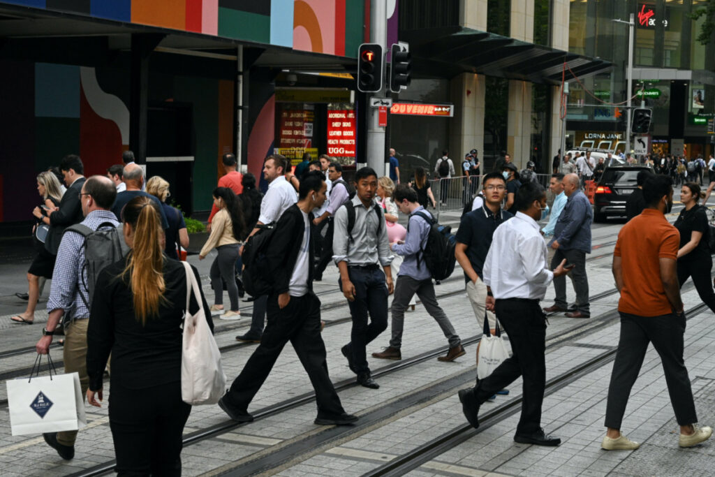 People cross a street in the city centre following further easing of coronavirus disease restrictions in Sydney, Australia, on 10th December, 2020.