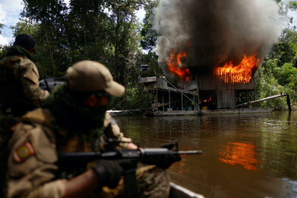 An illegal gold dredge burns in Paruari river during an operation against illegal gold mining at the Urupadi National Forest Park in the Amazon rainforest, conducted by agents of the Chico Mendes environmental agency ICMBio with support of the Federal Police, the Federal Highway Police, Brazilian Intelligence Agency agents and Brazilian Public-Safety National Force officers, in the municipality of Maues, Amazonas state, Brazil, on 1st June, 2023