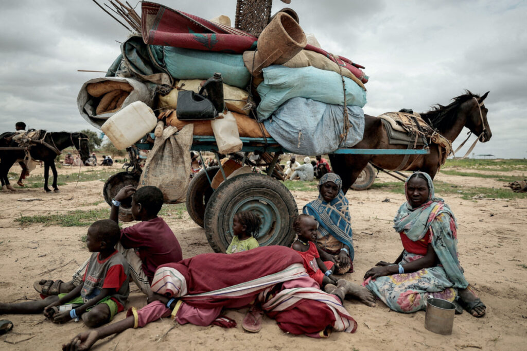 A Sudanese family who fled the conflict in Murnei in Sudan's Darfur region, sit beside their belongings while waiting to be registered by UNHCR upon crossing the border between Sudan and Chad in Adre, Chad, on 26th July 2023