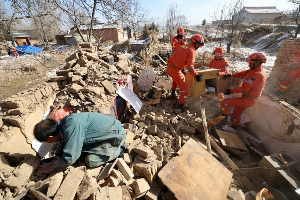 Rescue workers retrieve belongings from a damaged house at Shiyuan village following the earthquake in Jishishan county, Gansu province, China on 20th December, 2023.