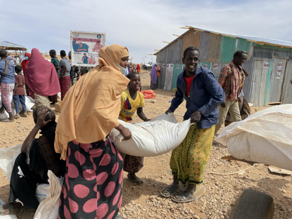 People carry bags of relief grains at a camp for the Internally Displaced People in Adadle district in the Somali region, Ethiopia, on 22nd January, 2022.