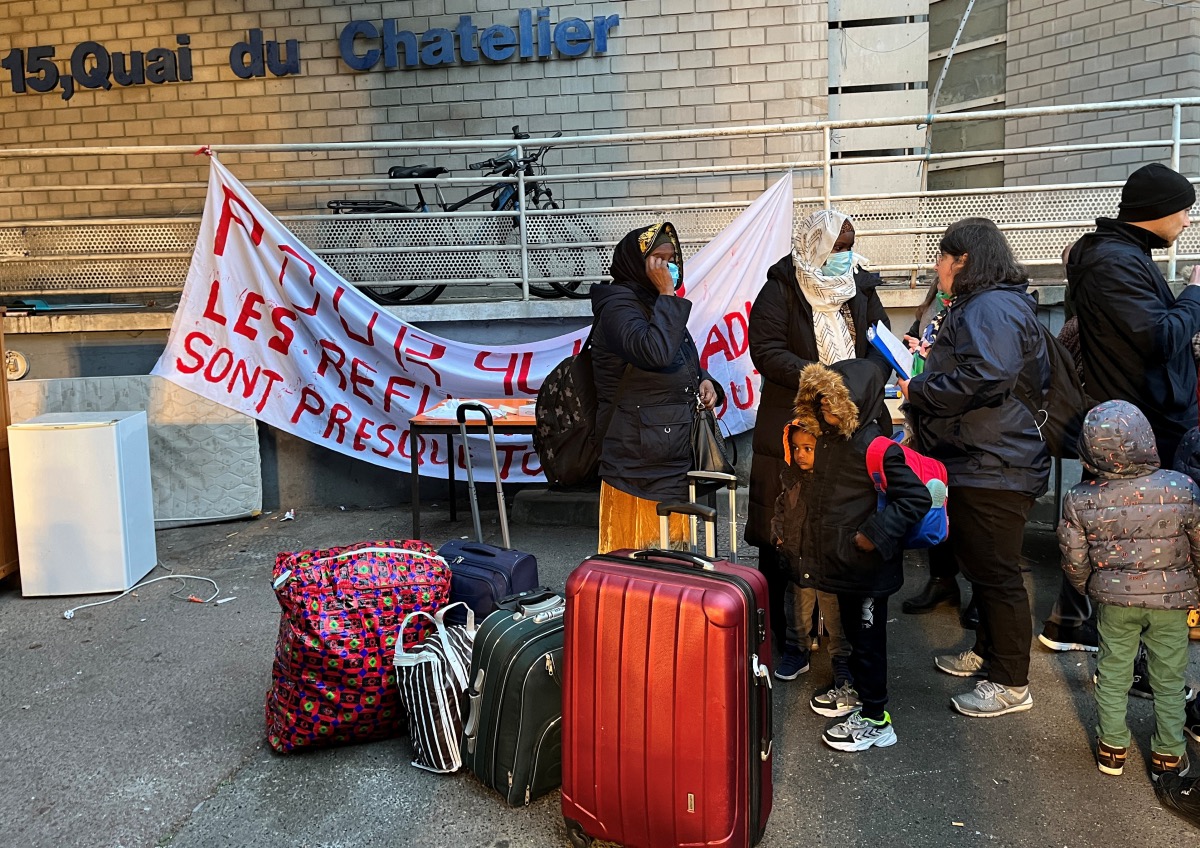 Families wait with their suitcases after being evicted from a squat in a disused industrial building not far from the Paris 2024 Olympic Athlete's Village in Ile-Saint-Denis, near Paris, France, on 26th April, 2023
