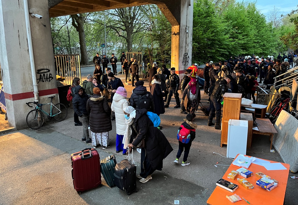 Families wait with their suitcases after being evicted from a squat in a disused industrial building not far from the Paris 2024 Olympic Athlete's Village in Ile-Saint-Denis, near Paris, France, 26th April, 2023. 